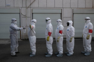 Volunteers in protective suits are being disinfected in a line in Wuhan, the epicentre of the novel coronavirus outbreak, in Hubei province, China February 22, 2020. Picture taken February 22, 2020. China Daily via REUTERS ATTENTION EDITORS - THIS IMAGE WAS PROVIDED BY A THIRD PARTY. CHINA OUT. - RC2U6F9A4U08