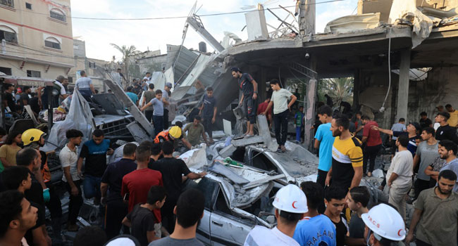 Palestinians inspect the debris after an Israeli strike near an United Nations Relief and Works Agency for Palestine Refugees (UNRWA) school in Khan Yunis, in the southern Gaza Strip on October 21, 2023. (Photo by Mahmud HAMS / AFP)