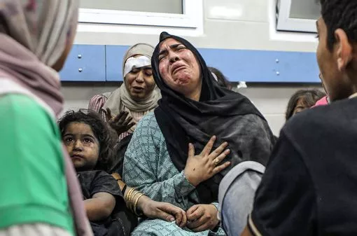 A woman cries and a child stares straight ahead following the horrific airstrikes